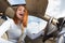 Wide angle view of young redhead woman driver fastened by seatbelt driving a car smiling happily