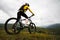 Wide angle. Young woman in a helmet and with a backpack stands with a bicycle mountains in cloudy weather. Mountain mtb