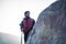 Wide angled shot of a indian traveler hiking up the mountain, shot at a shallow depth of field from a rock. Trekking with a