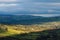 A wide beam of sunlight highlights farms and fields in the Irish landscape