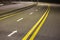 Wide bright yellow street marking sign line along modern wide smooth empty asphalt highway stretching to horizon. Speed, safety,