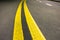 Wide bright yellow street marking sign line along modern wide smooth empty asphalt highway stretching to horizon. Speed, safety,