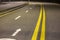 Wide bright yellow street marking sign line along modern wide smooth empty asphalt highway stretching to horizon. Speed, safety,