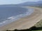 Wide deserted coastal beach with low tide and sand dunes