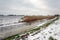 Wide ditch covered with ice in a snowy Dutch polder landscape