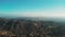 Wide drone shot over hills and mountains near Los Angeles, California on sunny day