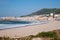 Wide empty beach with beautiful waves and white town on background. Vila Praia de Ancora, Portugal, landmark.