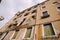 Wide frame from below on a building facade in Italy, Venice. The four-story building is sand-colored with windows with