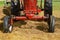 Wide front wheeled red tractor pulling a baler