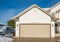 Wide garage door of luxury house with concrete driveway and RV wagon parked nearby