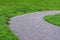 Wide gravel path curved through grass and lined by mole hills