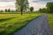 wide gravel path winding through a serene meadow