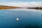 A wide large river, a white buoy floats on the water.