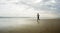 Wide lens silhouette of afro American runner woman jogging on the beach - young attractive and athletic black girl training