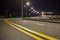 Wide modern smooth empty illuminated with street lamps asphalt highway with bright white marking sign line at night. Speed, safety