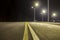 Wide modern smooth empty illuminated with street lamps asphalt highway with bright white marking sign line at night. Speed, safety