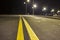 Wide modern smooth empty illuminated with street lamps asphalt highway with bright white marking sign line at night. Speed, safety