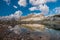 Wide open skies and a sheer mountain cliff above a serene alpine lake