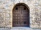 Wide outdoor wooden door in stone medieval house