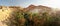 Wide panorama of Chebika oasis with Atlas mountains in midday sun backlight. Tunisia