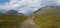 Wide panorama of Kungsleden hiking trail path with red marked stones in beautiful wild Lapland nature landscape with green bushes