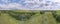 Wide panorama of Overhead power line transmission tower at summer