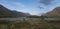 Wide panoramatic Lapland nature landscape with cofluence of wild Tjaktjajakka river and Kaitumjaure lake with small birch tree