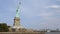 Wide panoramic shot of world famous Statue of Liberty national monument and New York City skyline, view from the water.