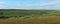 Wide panoramic view of yorkshire dales landscape with fields and farmhouses enclosed by stone walls with open moorland above