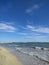 A wide sandy beach, the Mediterranean Sea with small waves