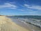 A wide sandy beach, the Mediterranean Sea with small waves