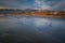 Wide sandy beach with people, Pacific ocean, hills, and cloudy sky. Pismo Beach at sunset, California coastline