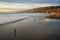 Wide sandy beach at sunset, golden hills, and beautiful cloudy sky on background. Pismo Beach sunset, California