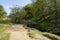 Wide sandy path to a small wooden bridge across Burbage Brook