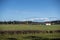 Wide, scenic view of a white barn on a large plot of farm land in the Pacific Northwest