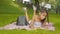 Wide shot of absorbed concentrated girl lying on green meadow in park and reading book. Portrait of charming African