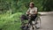 Wide shot African American young military man in wheelchair looking away admiring beauty of summer nature in parkland