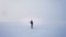 Wide shot of alone caucasian musician playing trumpet actively and emotionally on frozen lake background.