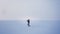 Wide shot of alone caucasian musician playing trumpet actively on frozen lake background.