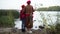 Wide shot back view elegant grandmother and granddaughter standing on river bank talking. Happy confident relaxed