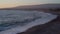Wide shot bay of Mediterranean sea in twilight with foamy waves rolling on coast in dusk. Calm idyllic tourist resort at