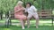 Wide shot of blond senior woman yelling at ear of deaf friend. portrait of relaxed Caucasian female retirees sitting on