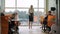 Wide shot of Caucasian teacher and children in primary school. Confident slim beautiful woman teaching pupils in