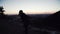 Wide shot of a caucasian woman working out with a kettlebell at dawn.