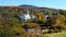 Wide shot of a church in stowe with a hill covered in fall foliage