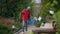 Wide shot of confident man with garden garbage walking away outdoors leaving. Portrait of serious male African American