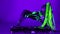 Wide shot cyborg woman dancing on DJ set in ultraviolet light looking at camera. Flexible slim Caucasian performer with