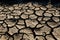 Wide shot of a desiccated landscape, barren and cracked due to drought and extreme heat