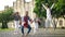 Wide shot four joyful multiethnic students jumping up in slow motion laughing looking at camera. Portrait of positive