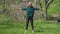 Wide shot front view of fit retiree exercising reaching tiptoes with hands. Portrait of Caucasian athletic sportswoman